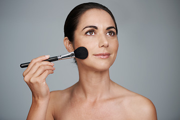 Image showing Makeup, brush and mature woman in studio with beauty, natural and facial glow routine. Cosmetics, self care and confident female person from Canada with cosmetology tool isolated by gray background.