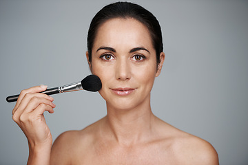 Image showing Beauty, brush and portrait of woman in studio with makeup, natural and facial glow routine. Cosmetics, self care and confident mature female person with cosmetology tool isolated by gray background.