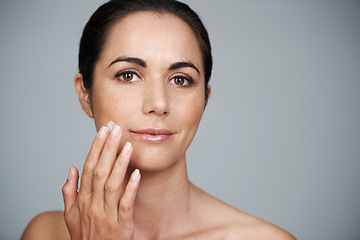 Image showing Portrait, woman and apply cream for skincare or moisturizer in studio isolated on a gray background. Face, cosmetics and mature model with lotion for dermatology, beauty and hydration for anti aging