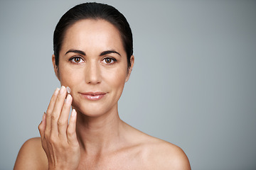 Image showing Portrait, woman and face cream in studio for anti aging, skincare and cosmetics in gray background. Female person, moisturizer and daily routine or self care, confidence and skin tone in mockup space