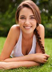 Image showing Woman, portrait and smile on grass for relax with sunshine, enjoyment or weekend break in summer. Young person, happiness or confident on lawn, garden or backyard of home for fresh air in environment