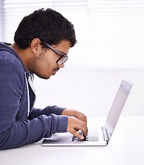 Image showing University, focus and man typing with laptop for research, study or elearning for education, knowledge and opportunity. Computer, reading and college student writing for online course with glasses.