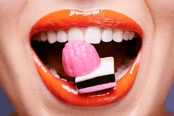 Image showing Beauty, lipstick and woman with sweets in mouth, makeup and creativity with closeup of shiny cosmetic product. Licorice, candy and orange lip gloss for aesthetic, art and cosmetology with glamour