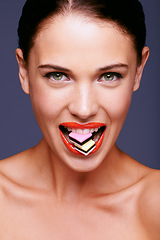 Image showing Beauty, lipstick and woman in portrait with candy in mouth, makeup and creativity with shiny cosmetic product. Licorice, sweets and orange lip gloss for aesthetic with art on purple background