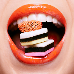 Image showing Closeup, lipstick and woman with candy in mouth, makeup and creativity with shiny cosmetic product for beauty. Licorice, sweets and orange lip gloss for aesthetic, art and cosmetology with glamour