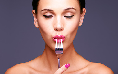 Image showing Woman, studio and fork with makeup, skin and beauty for creative diet. Model, closeup and face with lipstick, lip gloss and aesthetic for glamour and health or wellness with silverware and bliss