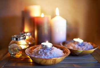 Image showing Spa, candle and oil with salt for peace in room for luxury with aromatherapy to relax, zen and meditation. Aromatic or cosmetic liquid, table and candlelight for mindfulness or wellness and self care