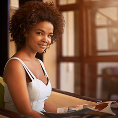 Image showing Portrait, smile and black woman reading magazine at window in living room of home for weekend leisure. Book, morning and relax with confident young afro person in apartment for casual time off