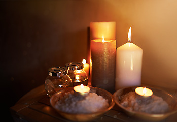 Image showing Spa, candle and oil with salt for meditation in room for peace or luxury with aromatherapy to relax. Aromatic or cosmetic liquid, table and candlelight for mindfulness or wellness and self care.
