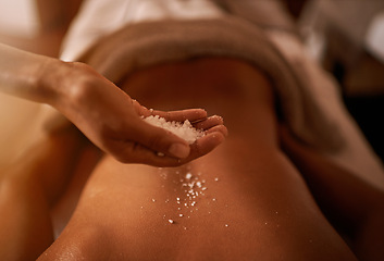 Image showing Hand, back and salt at spa for massage, skin care and wellness for luxury, holistic therapy and peace. Grain, exfoliate and health for lifestyle, body and person on table, calm and natural