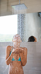 Image showing Showering, wet and woman with wellness, bikini and healthy with morning routine and body. Person, hotel and girl with water and underwear with cleaning, grooming and happy with hospitality and liquid