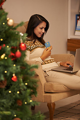 Image showing Home, Christmas and woman online shopping with laptop and credit card, payment and promotion on holiday. Ecommerce, customer and girl on sofa with sale, transaction and buying present or gift