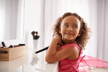 Image showing Child, playing and mirror with makeup for costume, ballet or performance with cosmetics or smile. Naughty, playful girl and happy kid in with a fantasy, foundation or blusher in the home or house