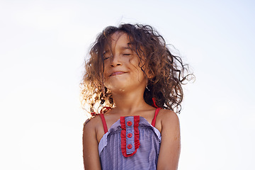 Image showing Child, girl and water with face, costume and blue summer sky for relax and smile. Kid, youth and sunshine with happiness, outdoor and play with curly hair and fun for sunny positivity and childhood