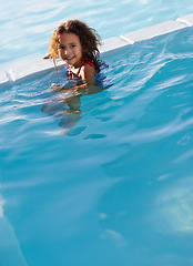 Image showing Child, girl and water with face, swimwear and blue summer sky for relax and smile. Kid, pool and sunshine with happiness, outdoor and play with curly hair and fun for sunny positivity and childhood