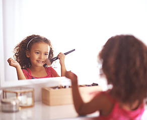 Image showing Child, brush and mirror with makeup for skincare, beauty or happiness with cosmetics or smile. Girl, grooming and reflection of a young kid in with foundation, space or blusher in the home or house