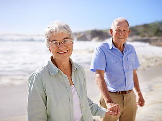 Image showing Senior, couple and holding hands on beach for portrait on retirement vacation or anniversary to relax with love, care and commitment with support. Elderly man, woman and together by ocean for peace.