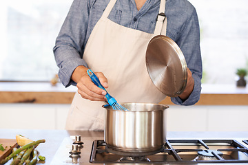 Image showing Hands, chef and cooking in kitchen with pot, wellness and food with nutrition for health in home. House, stove and person with apron for fresh ingredients to eat for lunch, diet and soup on gas