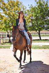 Image showing Cowgirl, woman and smile with horse for ride in ranch, farm or nature with tree outdoor on weekend. Happy person and excited with animal on sand in sun with saddle and fun in texas on summer