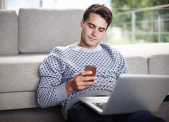 Image showing Man, phone and relax with sofa in living room for tech, social media and research in home or indoor on weekend. Male person or freelancer and looking on screen for browse with internet and online