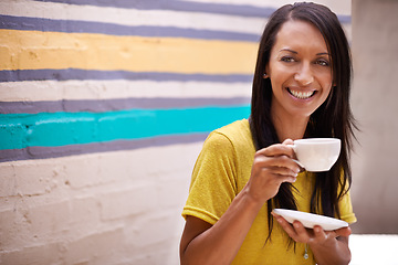 Image showing Woman, drinking coffee and smile outdoors, relax and laughing for humor or comedy by wall background. Female person, happy and hot beverage for positive attitude, comic and cup for tea or confidence