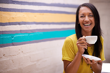 Image showing Woman, drinking tea and smile outdoors, relax and laughing for humor or comedy by wall background. Female person, happy and hot beverage for positive attitude, comic and cup for latte or confidence