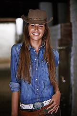 Image showing Woman or cowgirl, happy and portrait in stable for work or rodeo in Texas, western and culture for farming. Female cowboy or jockey, ranch and hat for barn agriculture and countryside with equestrian