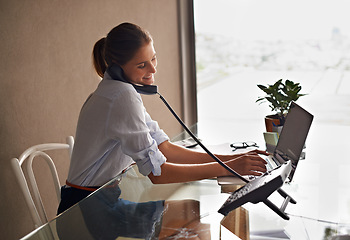 Image showing Businesswoman, laptop and talking on phone professional, formal clothes and working in office. Female person, smile and communicate with clients or consultant, communication and typing in computer