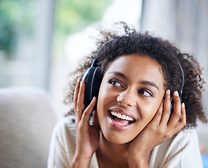 Image showing Headphones, smile and happy woman person on couch, living room and listening to music. Happy, joyful or thinking while streaming audio, podcast or radio for entertainment for African female listener