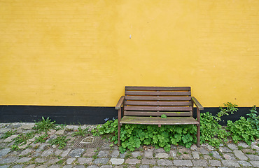 Image showing Wooden wall, bench and outdoor with plants, structure and furniture with mockup space. Outside, chair and stones with texture and design with summer and building with light and growth with street