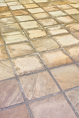 Image showing Tiled, ground and aerial view with closeup, texture and cement with layout and design. Grid, floor and patterns with stone and sunshine with light and summer with architecture and outdoor with earth