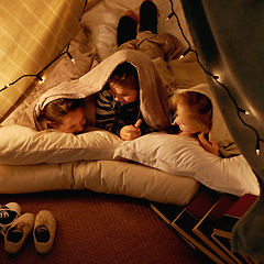 Image showing Children, happy and sleepover in tent at night with conversation, bonding and holiday adventure or vacation. Young friends or kids by fairy lights, pillows and blanket at home for fun storytelling
