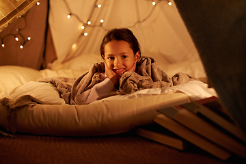 Image showing Portrait, happy and girl in a bedroom fort in a house for holiday, games or staycation fun. Face, smile and happy kid in a diy tent for playing, resting or enjoy weekend with camping fantasy in house