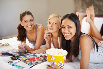 Image showing Friends, popcorn and portrait for sleepover, social and bedroom for bonding and excited group for snacks. Female people, together and magazines for jokes, besties and entertainment with conversation