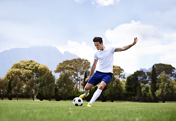 Image showing Man, soccer player and shooting with ball on field with power, speed and aim at target in training for club. Person, football and sport with kick exercise and workout for wellness, fitness and game