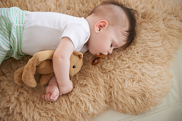 Image showing Toddler, sleep and home with teddybear in sofa to rest, tired and relax with dummy and dream. High angle, baby, and nap in couch for child development, growth and innocent with peace for bedtime.