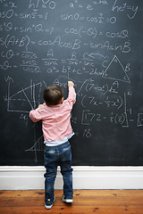 Image showing Child, math and blackboard with writing in classroom for knowledge, development and young genius in school. Kid, numbers and formula on chalkboard with learning for education, growth and solution