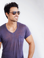 Image showing Happy, man and fashion with sunglasses on wall outdoor with confidence, cool style and pride. Summer, holiday and person smile in casual outfit for vacation, break and relax on white background