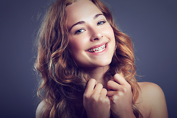 Image showing Portrait, beauty and braces with smile of woman in studio on dark background for natural wellness. Face, hair and dental care with happy young person looking satisfied with cosmetics or oral hygiene