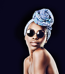 Image showing Portrait, beauty and fashion with African woman in studio isolated on black background for heritage. Culture, model and sunglasses with confident young person in trendy headwear for traditional style