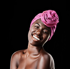 Image showing Black woman, head wrap and beauty portrait with smile, skincare and natural cosmetics in studio. Traditional, turban and African fashion with wellness and skin glow with makeup and dark background