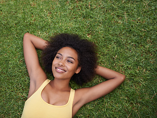 Image showing Happy, grass and above of black woman in park for thinking, wondering and relax in nature. Smile, garden and top view of person laying outdoors for holiday, vacation and weekend for calm or peace