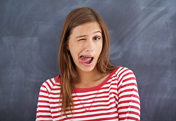 Image showing Tongue out, blackboard and portrait with woman, teacher and education with knowledge and silly. Face, funny and goofy with girl or educator with expression or emoji with reaction or quirky with humor