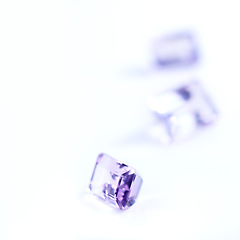 Image showing Amethyst, rocks or stone in studio by white background for natural resource, jewelry and baguette for luxury. Gemstone, purple crystal and closeup with shine, glow and brilliant cut for collection