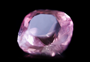 Image showing Pink diamond, jewel and stone by black background for natural resource, sparkle and luxury. Rocks, mineral and crystal in closeup for gem with shine, glow and brilliant cut with reflection in studio