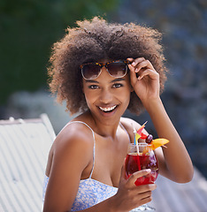 Image showing Black woman, tropical and sunglasses with cocktail for portrait or summer vacation, relax or happy for wellness at resort. Holiday, retreat or natural female person with liquid or fruit drink