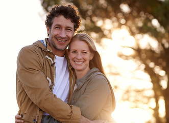 Image showing Happy, couple hug and portrait in park, love and support with date for bonding and time together. Sunset, nature and people in forest for fresh air, loyalty and commitment with smile outdoor