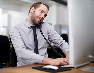 Image showing Man, phone and landline in office for customer service with telemarketing, help desk and happy with computer. Call center, employee and consultant with telephone for support, telesales and advice