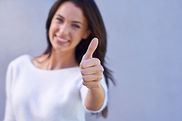 Image showing Thumbs up, happy and portrait of woman with success, winner and goal reached isolated on gray background. Hand, female person and gesture for yes, thank you and achievement with smile in studio
