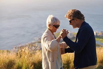 Image showing Happy, couple and dance outdoor on holiday, holding hands with love and relax on hill or mountain in Cape Town. Mature, people and embrace with kindness on vacation adventure in nature together